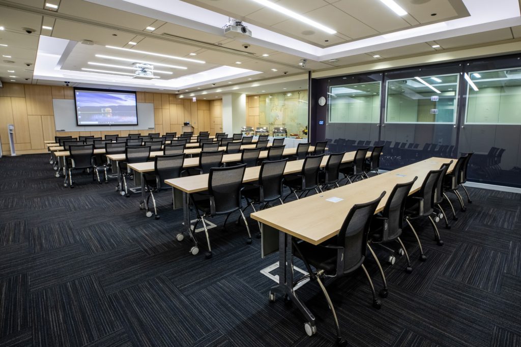 Conference Room 1AB at One Rotary Place. Photo of a large conference room with a projector and screen.