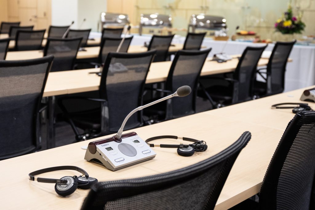 Conference Room 1A at One Rotary Place. Photo of a conference room table with a microphone and interpretation headset.