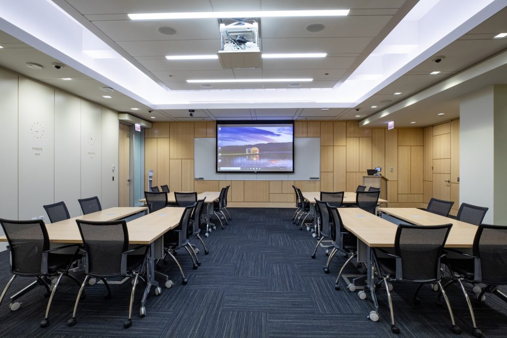 Conference Room 1A at One Rotary Place. Photo of a large conference room with a projector and screen.