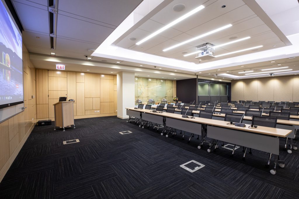 Conference Room 1A at One Rotary Place. Photo of a large conference room with a podium, projector, and screen.