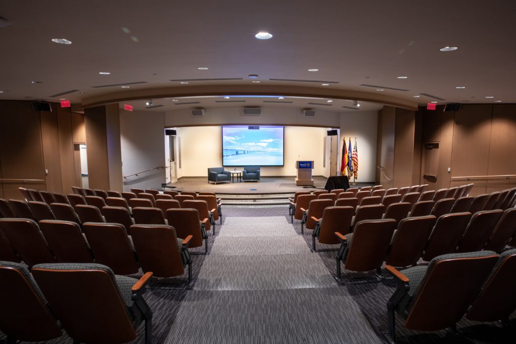 3rd Floor Auditorium at One Rotary Place. Photo of a large theater and stage featuring custom lighting and projections.